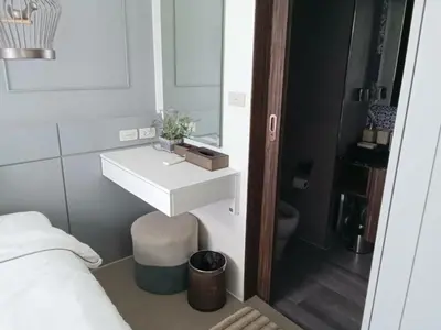 a bathroom with a white sink and a mirror at Palmyrah Surin Beach Residence in Surin Beach