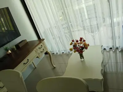 a white table with a vase of flowers on it at Palmyrah Surin Beach Residence in Surin Beach