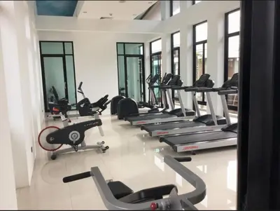 a gym with a row of treadmills and machines at Chalong Miracle Lakeview in Chalong