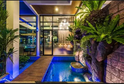 a pool in the middle of a building with plants at Chalong Miracle Lakeview in Chalong