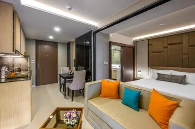a bedroom with a bed and a couch and a kitchen at Private Residents in Surin Mida in Surin Beach