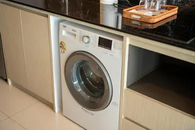 a washing machine in a kitchen under a counter at Private Residents in Surin Mida in Surin Beach