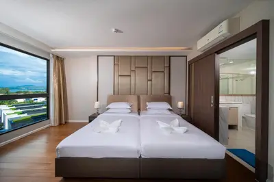 a bedroom with two beds and a large window at Private Residents in Surin Mida in Surin Beach