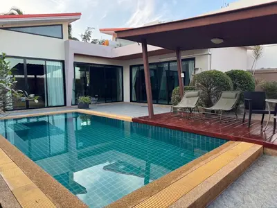 a swimming pool in front of a house at Pool villa Phuket in Kata Beach