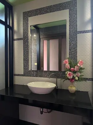 a bathroom sink with a vase of flowers on a counter at Pool villa Phuket in Kata Beach