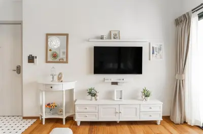 a white living room with a tv on a wall at Title Halo Romantic Suite Pool View Gym in Nai Yang Beach