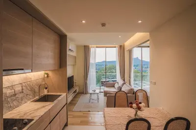 a kitchen and living room with a table and a couch at Luxury sea view apartments in Ao Nang Beach