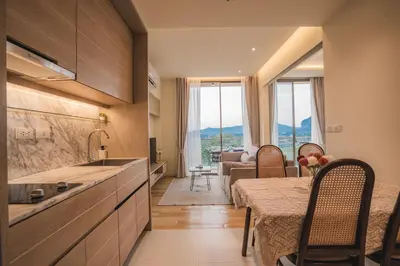 a kitchen with a table and a dining room at Luxury sea view apartments in Ao Nang Beach