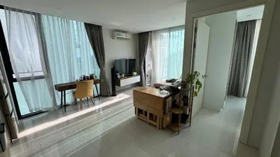 a living room with a table and a desk in a room at Patong Sea View pool view condo in Patong Beach