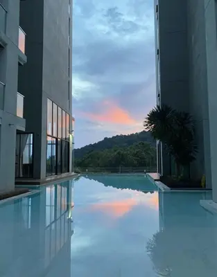 a view of a building with a reflection in a pool at Patong Sea View pool view condo in Patong Beach