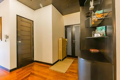 a room with two doors and a hallway with wood floors at 3BR Casa Blanc - Beachfront Home in Laguna & Layan Chom Tawan and Maan Tawan Residences in Phuket