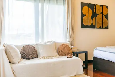 a living room with a white couch and a window at 3BR Casa Blanc - Beachfront Home in Laguna & Layan Chom Tawan and Maan Tawan Residences in Phuket