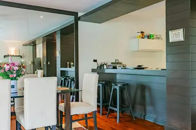 a kitchen and dining room with a table and chairs at 3BR Casa Blanc - Beachfront Home in Laguna & Layan Chom Tawan and Maan Tawan Residences in Phuket
