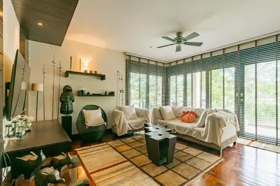 a living room with a couch and a ceiling fan at 3BR Casa Blanc - Beachfront Home in Laguna & Layan Chom Tawan and Maan Tawan Residences in Phuket