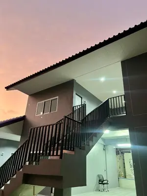 a house with a staircase in front of it at Boonyawat Apartment in Kata Beach