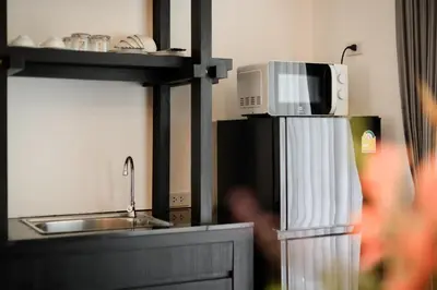 a kitchen with a microwave and a sink and a refrigerator at Noppharat Krabi Resort in Ao Nang Beach