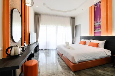 a bedroom with a bed and a desk and a mirror at Noppharat Krabi Resort in Ao Nang Beach