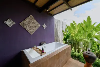 a bathroom with a bath tub with a large window at Noppharat Krabi Resort in Ao Nang Beach