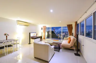 a living room with a view of a city skyline at Ocean and Mountainviews, 2 Balconies in Patong Beach