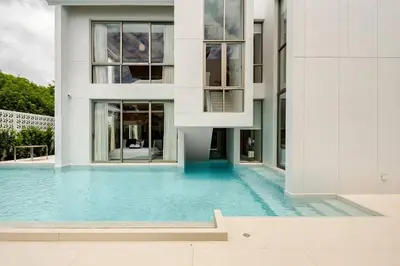 a house with a swimming pool in front of a building at Lux Pride Villa 3 bedroom Phuket Bang-Tao beach in Ban Phak Chit