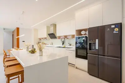 a kitchen with white cabinets and a black refrigerator at Lux Pride Villa 3 bedroom Phuket Bang-Tao beach in Ban Phak Chit