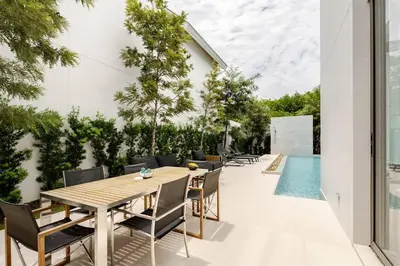 an outdoor dining area with a table and chairs and a pool at Lux Pride Villa 3 bedroom Phuket Bang-Tao beach in Ban Phak Chit