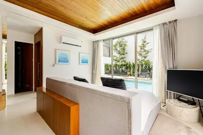 a living room with a large couch and a tv at Lux Pride Villa 3 bedroom Phuket Bang-Tao beach in Ban Phak Chit