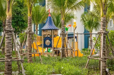 a playground in front of a building with palm trees at Title Halo I love Asia Naiyang Pool Gym in Nai Yang Beach
