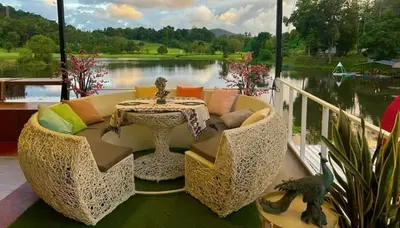 a patio with a couch and a table and a lake at Camping Phuket 88 in Kathu