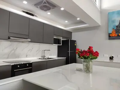 a kitchen with a vase of red flowers on a counter at Sawansa 34B 475m2 Luxury Sea view pool near beach in Patong Beach