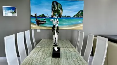 a dining table with white chairs and a painting on the wall at Sawansa 33A 400m2 Luxury Seaview Pool near Beach in Patong Beach