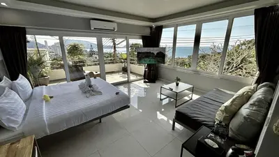 a bedroom with a bed and a couch and windows at Sawansa 33B 425m2 Luxury Seaview Pool near Beach in Patong Beach