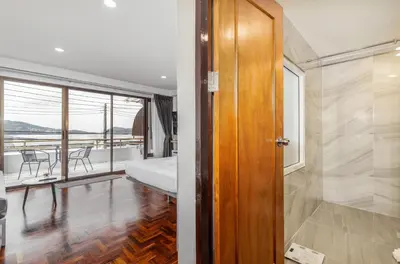 a bedroom with a bed and a balcony with a table at Sawansa 20 3BR 300m2 Modern Seaview house near Beach in Patong Beach