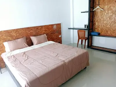 a bedroom with a bed and a table and a chair at Sawadee622,Naiharn & Rawai beach Phuket in Rawai Beach