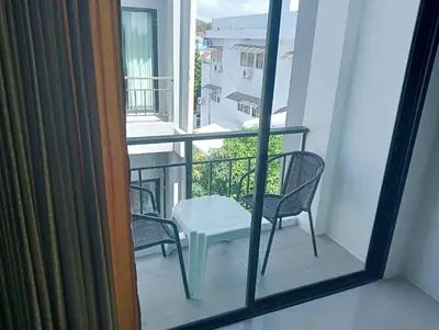 a balcony with two chairs and a table on a balcony at Sawadee622,Naiharn & Rawai beach Phuket in Rawai Beach