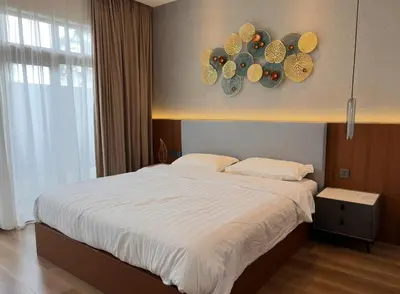 a bedroom with a large white bed and a window at Ocean Villa Bang Tao Phuket in Ban Thalat Choeng Thale