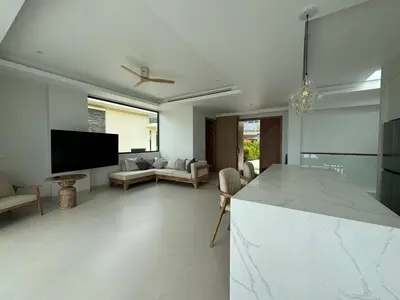 a kitchen and living room with a couch and a tv at MANDARIN villa, Naithon beach, Phuket in Phuket