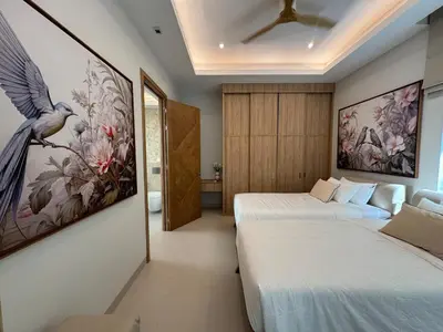 a bedroom with two beds and a bird painting on the wall at MANDARIN villa, Naithon beach, Phuket in Phuket