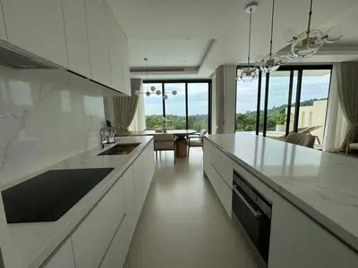 a kitchen with white counter tops and a dining room at MANDARIN villa, Naithon beach, Phuket in Phuket