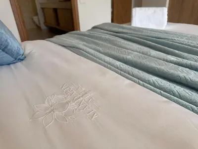 a white bed with a flower on it at MANDARIN villa, Naithon beach, Phuket in Phuket