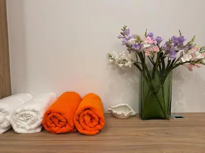 two towels and a vase of flowers on a shelf at MANDARIN villa, Naithon beach, Phuket in Phuket