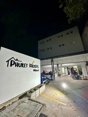 a building with a truck hostel sign in front of it at Phuket Hostel at Rawai in Phuket Town