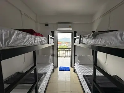 a room with three bunk beds and a doorway at Phuket Hostel at Rawai in Phuket Town