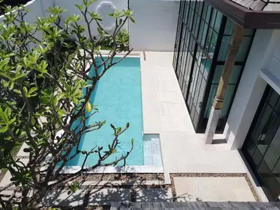a swimming pool in the middle of a house at Skyframe pool villa near Bangtao beach, Bluetree, Thalang in Ban Pak Lak