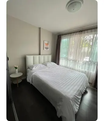 a white bed in a bedroom with a window at Dcondo kuku resort in Ban Phlu Yai