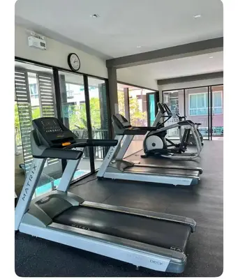 two exercise bikes in a gym with a clock at Dcondo kuku resort in Ban Phlu Yai