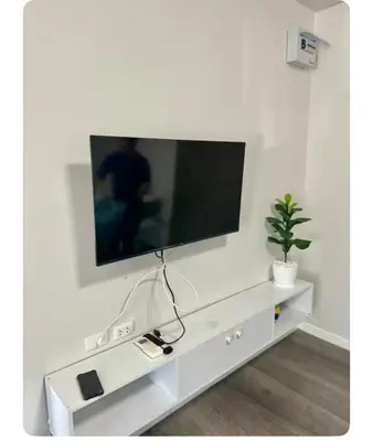 a white entertainment center with a tv on a wall at Dcondo kuku resort in Ban Phlu Yai