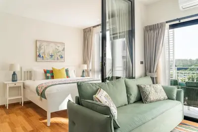 a living room with a bed and a couch at Title Halo Holi Day 40m2 King Bed Pool View in Nai Yang Beach