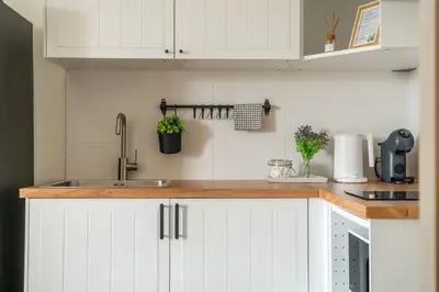 a kitchen with white cabinets and a sink at Title Halo Holi Day 40m2 King Bed Pool View in Nai Yang Beach