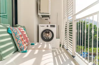 a dog is sitting in a washing machine on a balcony at Title Halo Holi Day 40m2 King Bed Pool View in Nai Yang Beach